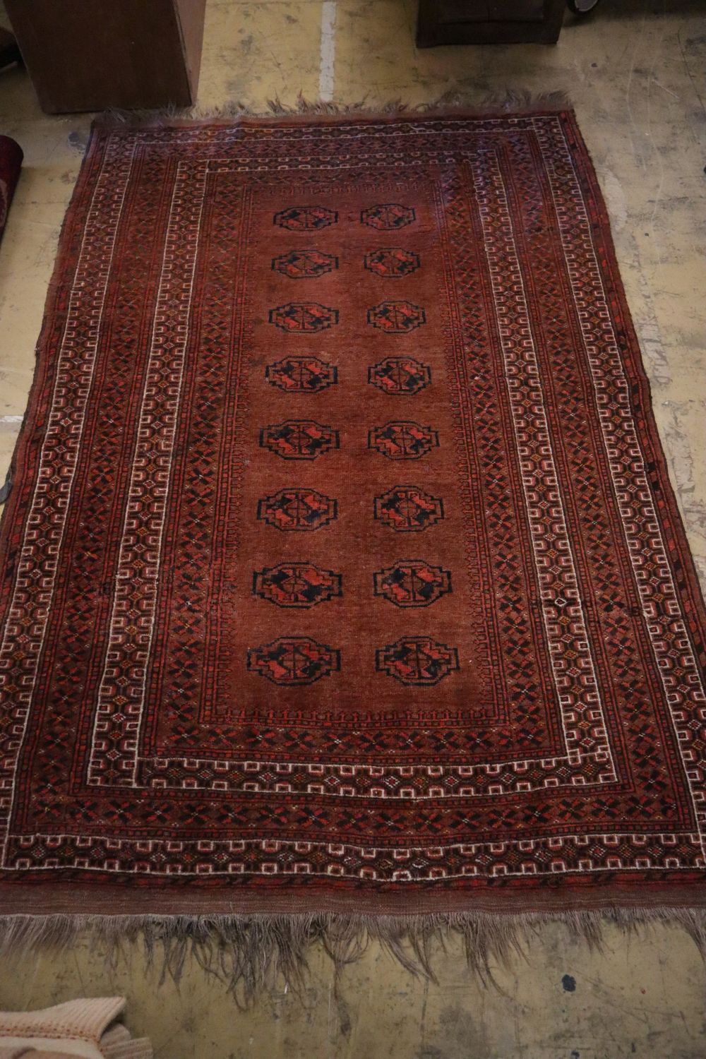 A Bokhara brick red ground rug, 217 x 147cm and a similar later rug, 110 x 74cm